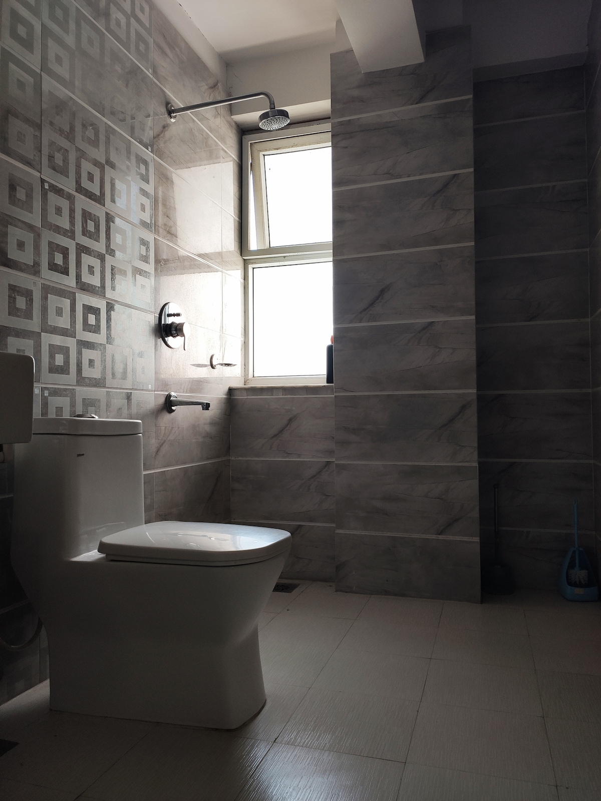 Bathroom with Toilet, Rain Shower Head & Patterned Grey Tiles
