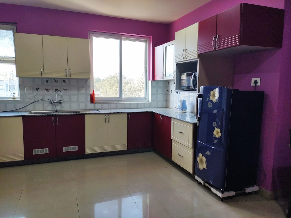 Fully Equipped Kitchen with Purple Cabinets, Fridge & Microwave