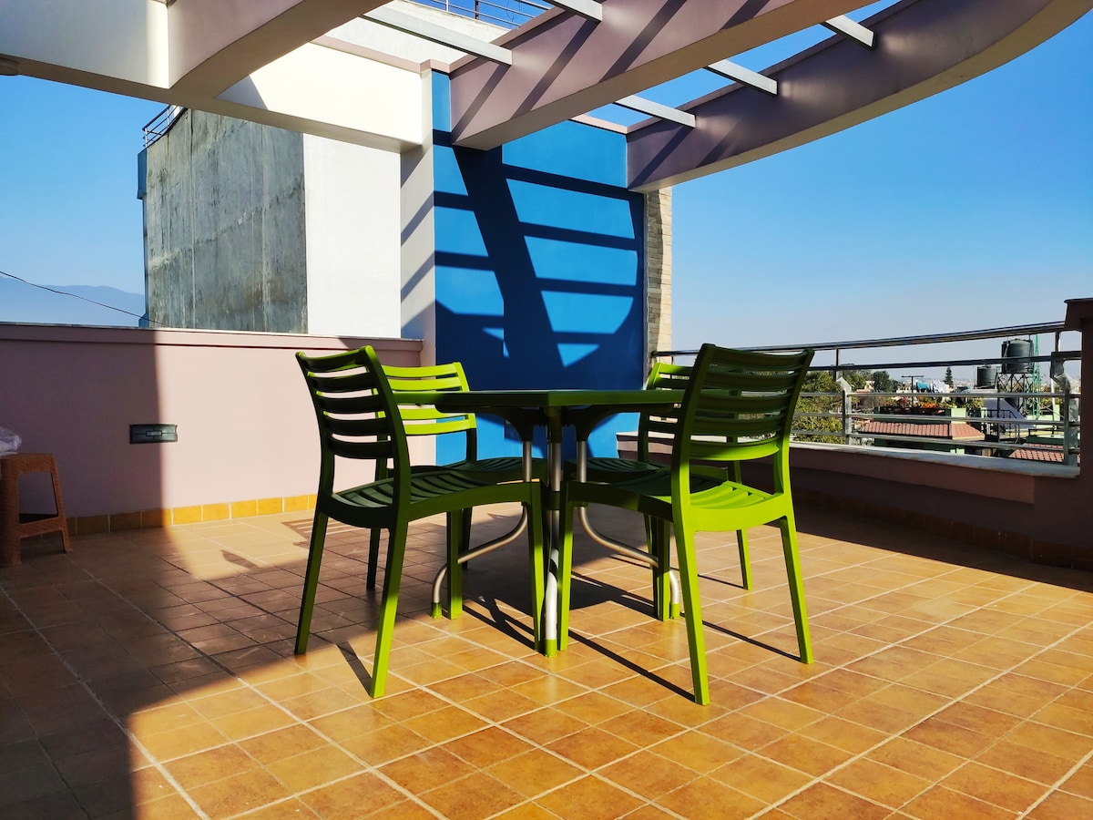 Rooftop Terrace with Green Chairs, Table & Open Sky View
